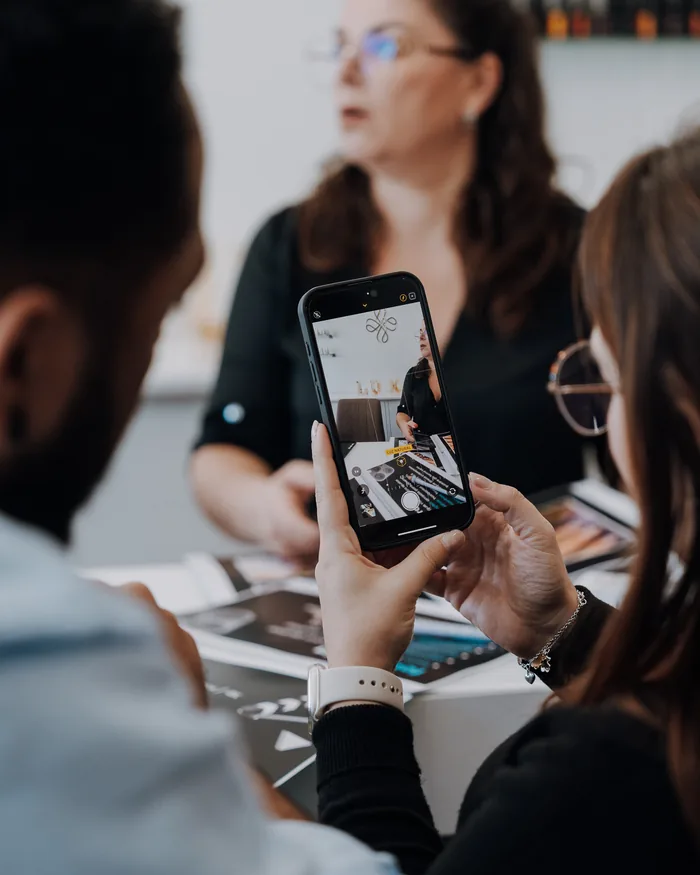 Um telemóvel a fotografar produtos dispostos sobre a mesa.