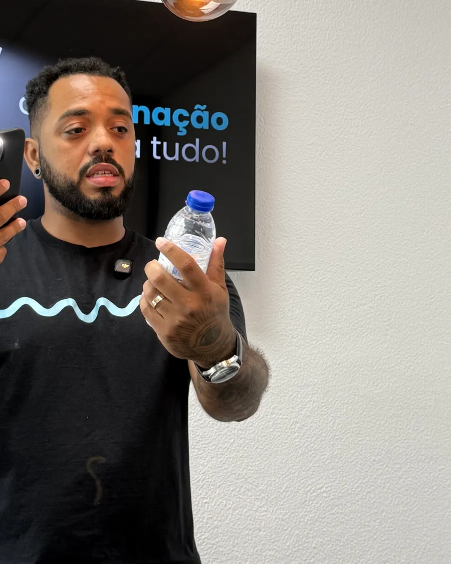 Weslley Rodrigues, formador do IQV, a demonstrar com o telemóvel como fotografar um produto.